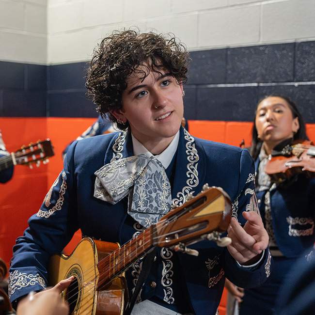 Person in Mariachi wear holding a guitar