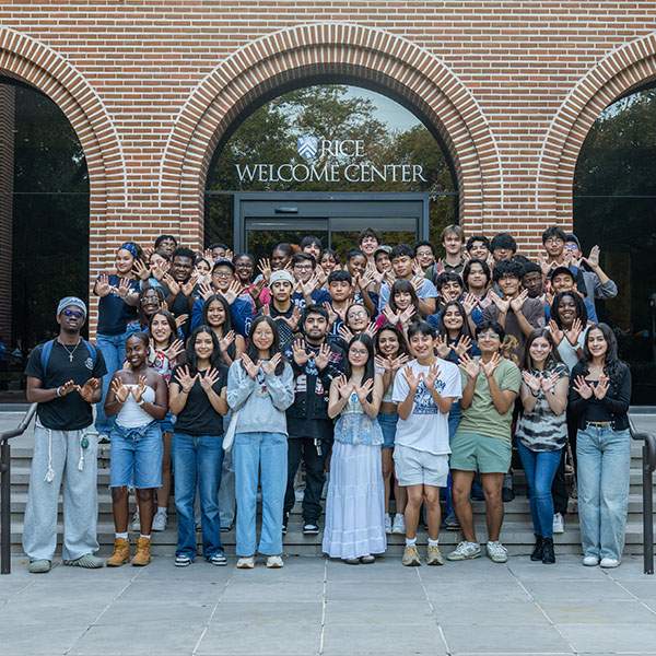 A large group of students holding up their hands like wings