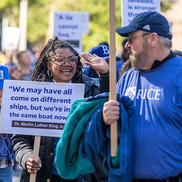Girl holding sign, man turned back to look at her