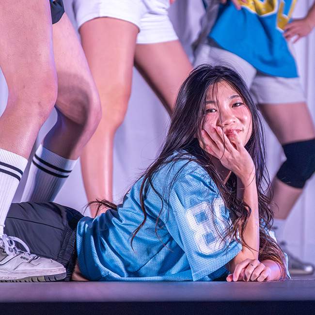 Girl lying down on the stage as part of dance performance