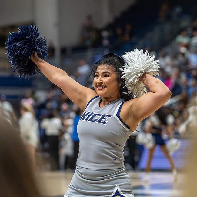 A girl mid-cheerleading pose, pom poms in her hands